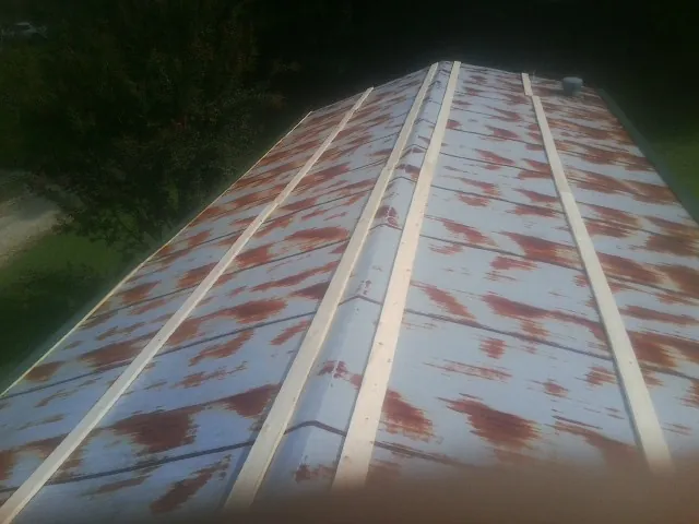 Rusted metal roof panels with new wood purlins before replacement — Storm Damage Roof Repair in Mc Callsburg by Roofing Brothers